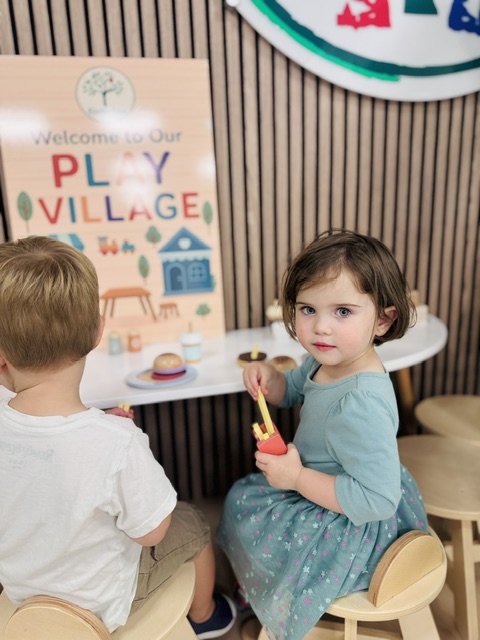 Child engaged in imaginative play at the Play Village area