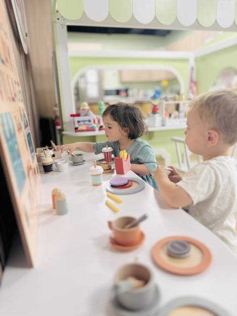 Children engaged in pretend cooking and dining activities